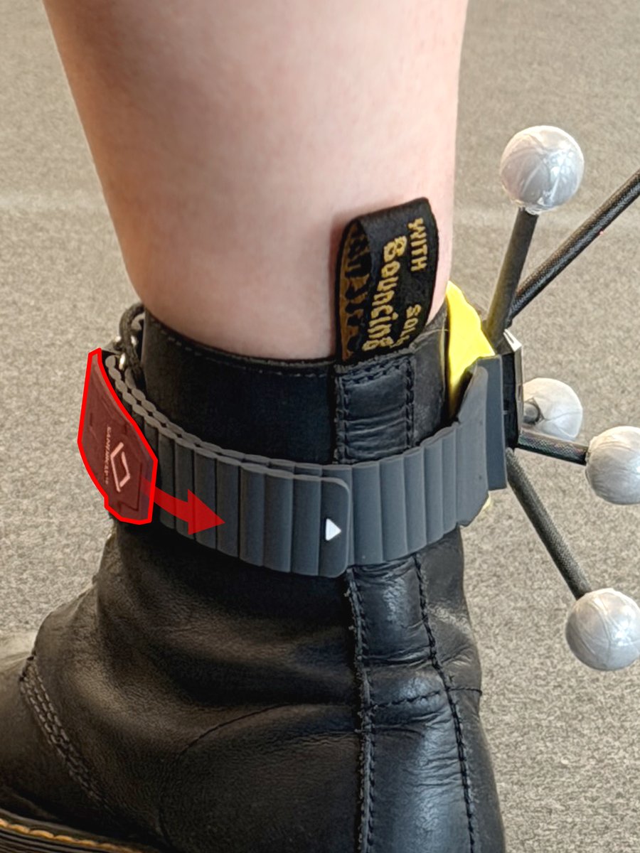 Protective flap on the ankle strap being lifted away from the fastener