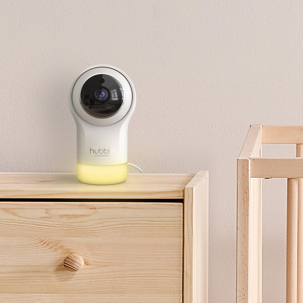 Hubble Nursery Pal Glow camera on a dresser beside a cot